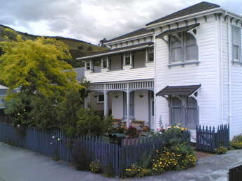 photo of the exterior of Amber House B&B in Nelson, New Zealand taken from the North West in late winter 2005. 
The centre of New Zealand is visible above the roofline. Amber House has the oldest English Walnut tree in the South Island and a brick chimney 
that survived at least 3 major local Earthquakes intact. Amber House also preserves Victorian wallpaper.
